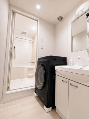 A modern bathroom with a washing machine, a sink, and a mirror. - Hotel ONE'S RESIDENCE (Sapporo)
