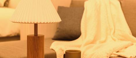 A wooden table with a lamp, a cup, and a box.