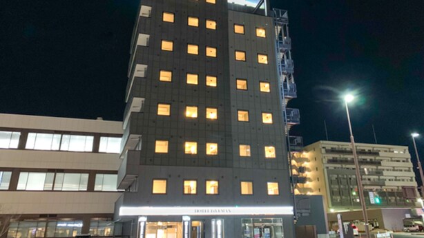 A multi-story hotel with illuminated windows and a sign indicating it is a hotel. - Hotel Live Max Okayama Kurashiki Station (Kurashiki)