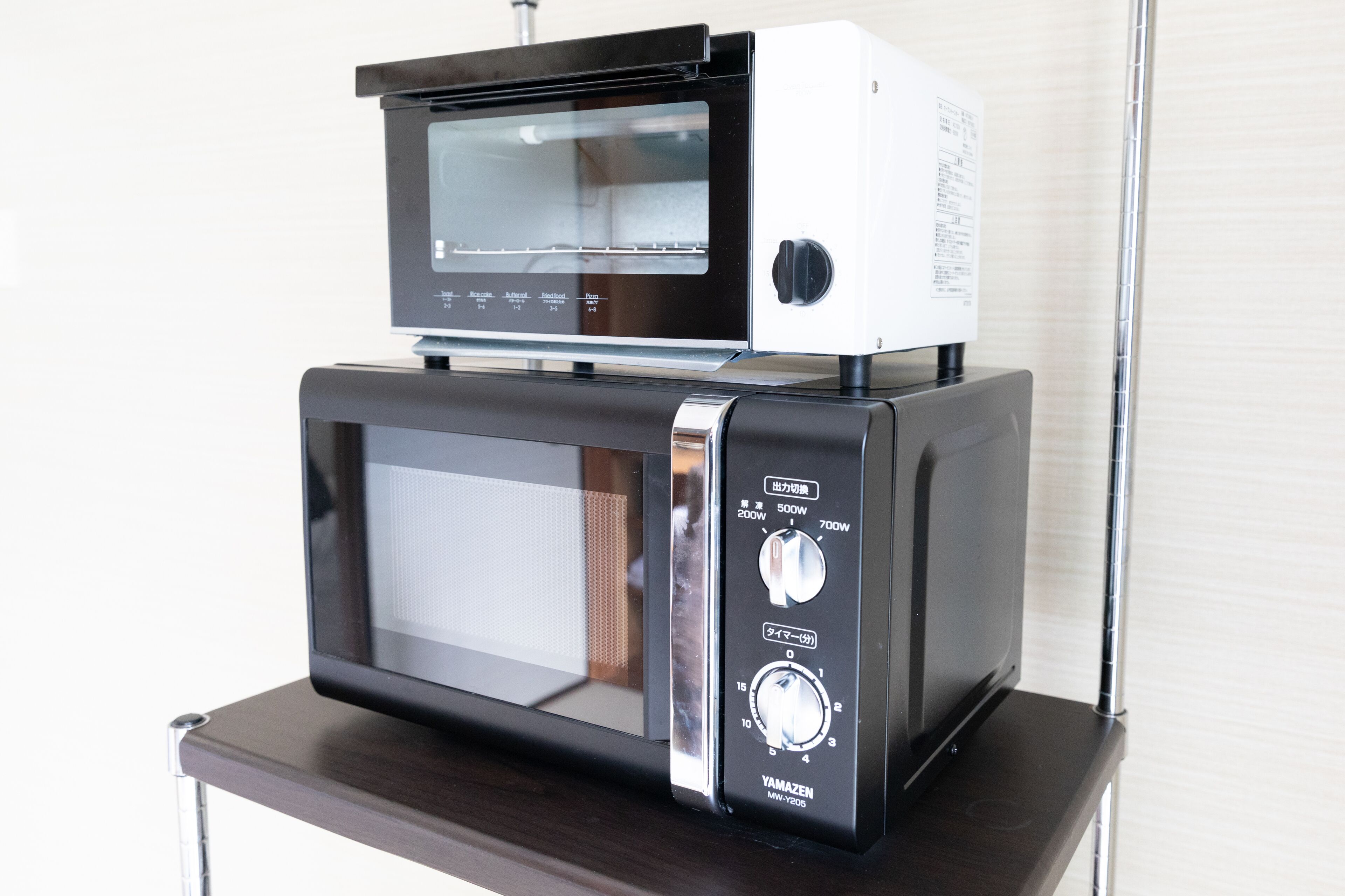 A microwave oven with a digital display and control panel, placed on a wooden surface.
