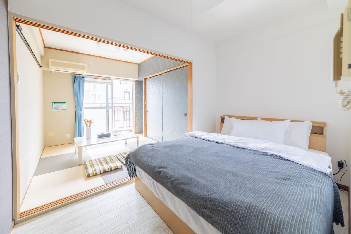 Quarto com cama, janela e vista para o exterior.