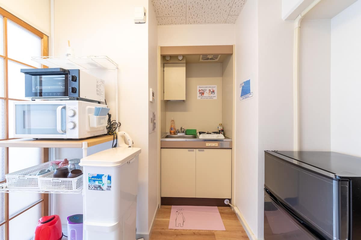 A compact kitchen with a microwave, toaster, and refrigerator.