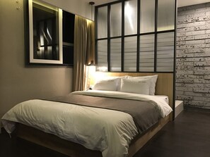 Un letto con struttura in legno, testiera con finestra e parete in mattoni.