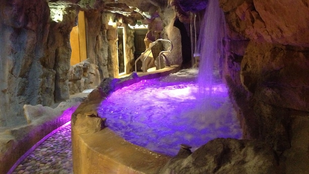 A cave-like interior with a water feature and a seating area. - Casanova - Family Apartments Residence (San Quirico d'Orcia)