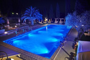 Una piscina al aire libre de temporada, sombrillas