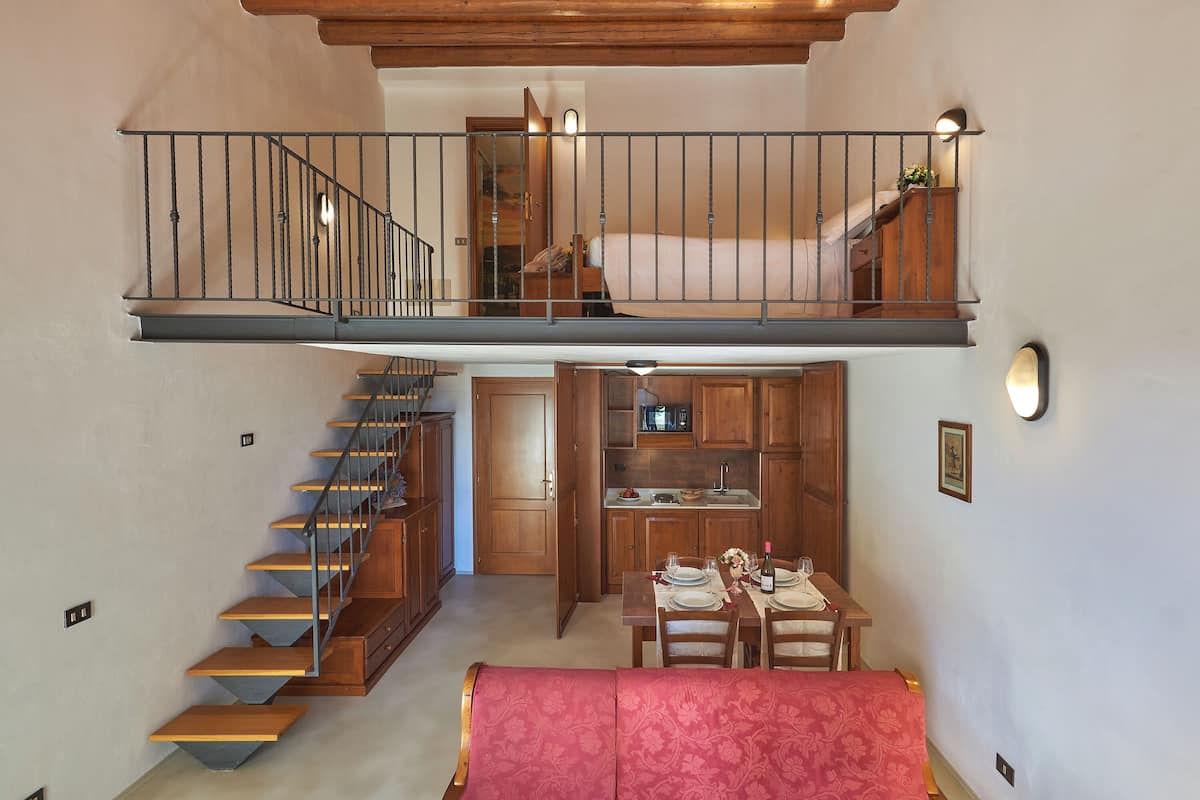 Ein zweistöckiges Haus mit Treppe, Essbereich und Küche.
