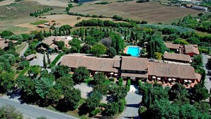 An aerial view of a villa complex with multiple buildings, a swimming pool, and surrounding vineyards. - Casanova - Family Apartments Residence (San Quirico d'Orcia)