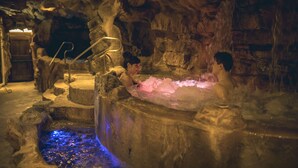 A spa area with a hot tub and a small pool, surrounded by stone walls and a wooden bench. - Casanova - Family Apartments Residence (San Quirico d'Orcia)