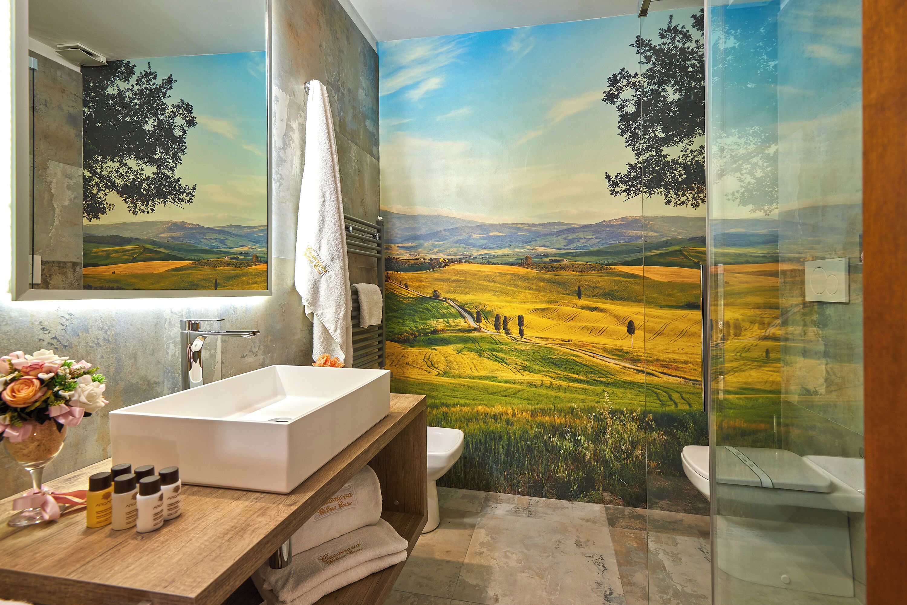 A bathroom with a large mirror, a white sink, and a shower area.