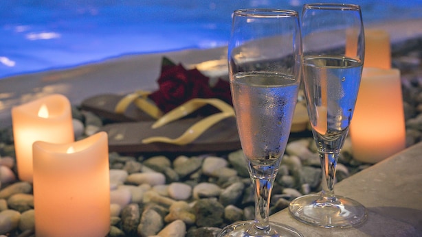 A poolside area with two glasses of water, candles, and a stone pathway. - Casanova - Panoramic Rooms and Suites (San Quirico d'Orcia)