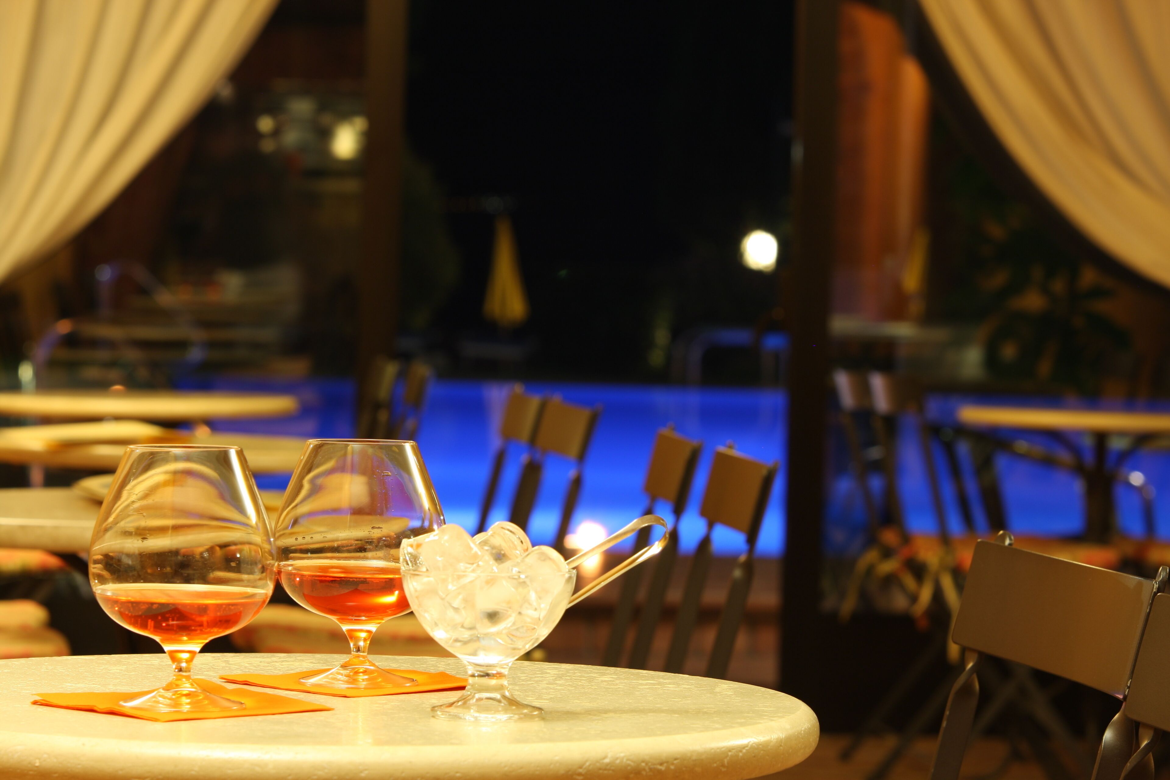 Comedor con mesas, sillas y vista a una piscina.