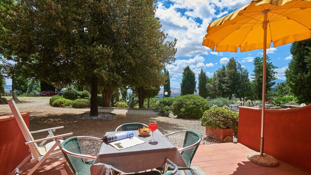 An outdoor patio with a table, chairs, and an umbrella.