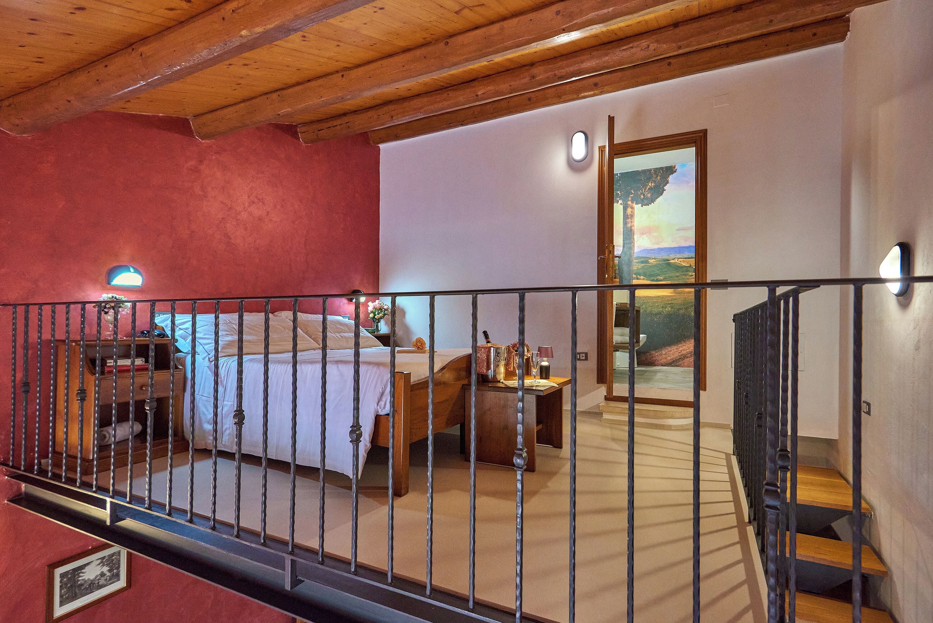 A bedroom with a bed, bedside table, and a painting on the wall.