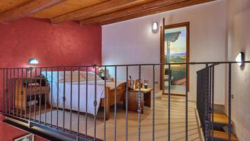 A bedroom with a bed, bedside table, and a painting on the wall.