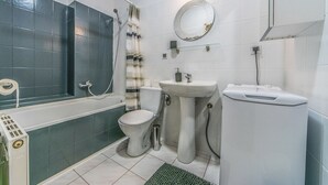 A bathroom with a bathtub, toilet, sink, and a shower with a curtain. - Victus Apartamenty - Poggio (Sopot)