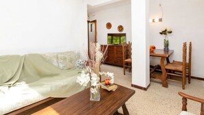 A living room with a sofa, a wooden coffee table, and a dining area with a table and chairs.