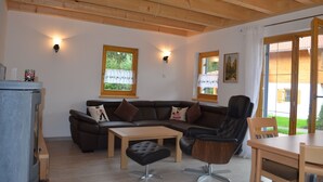 Een moderne woonkamer met een hoekbank, een houten tafel en een leren fauteuil.