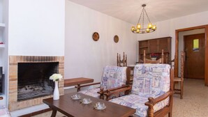 Una sala de estar con chimenea, muebles de madera y un candelabro.
