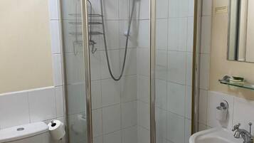 A modern bathroom with a glass-enclosed shower, a toilet, and a sink.