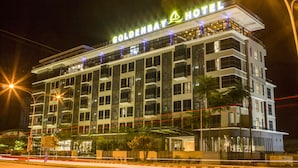 Een meerhoog hotel met een opvallend bord waarop 'Goldenbay Hotel' staat.