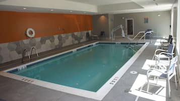 Relax by the rectangular pool surrounded by lounge chairs and safety signs.