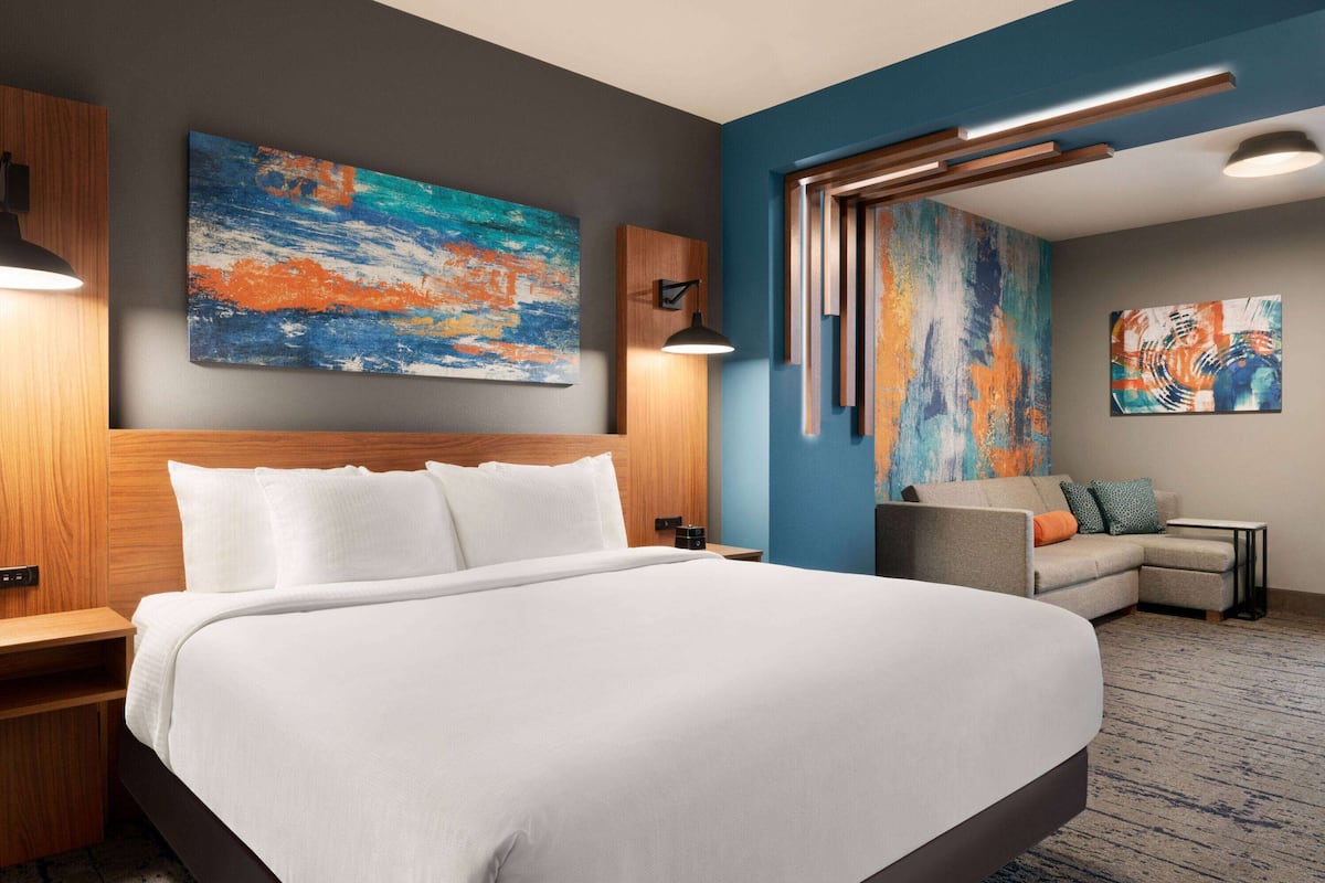 Ein Hotelzimmer mit einem großen Bett, einer Couch und zwei Bildern an den Wänden.