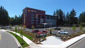 A hotel with a modern design, featuring a prominent 'La Quinta' sign, a parking lot, and a landscaped area with trees and shrubs. - La Quinta Inn & Suites by Wyndham Marysville (Marysville)