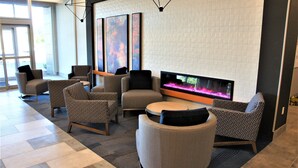 A modern lounge area with multiple seating options, a large flat-screen TV, and a fireplace. - La Quinta Inn & Suites by Wyndham Marysville (Marysville)