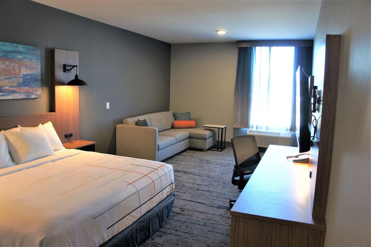 Een hotelkamer met een bed, een bank, een bureau en een televisie.