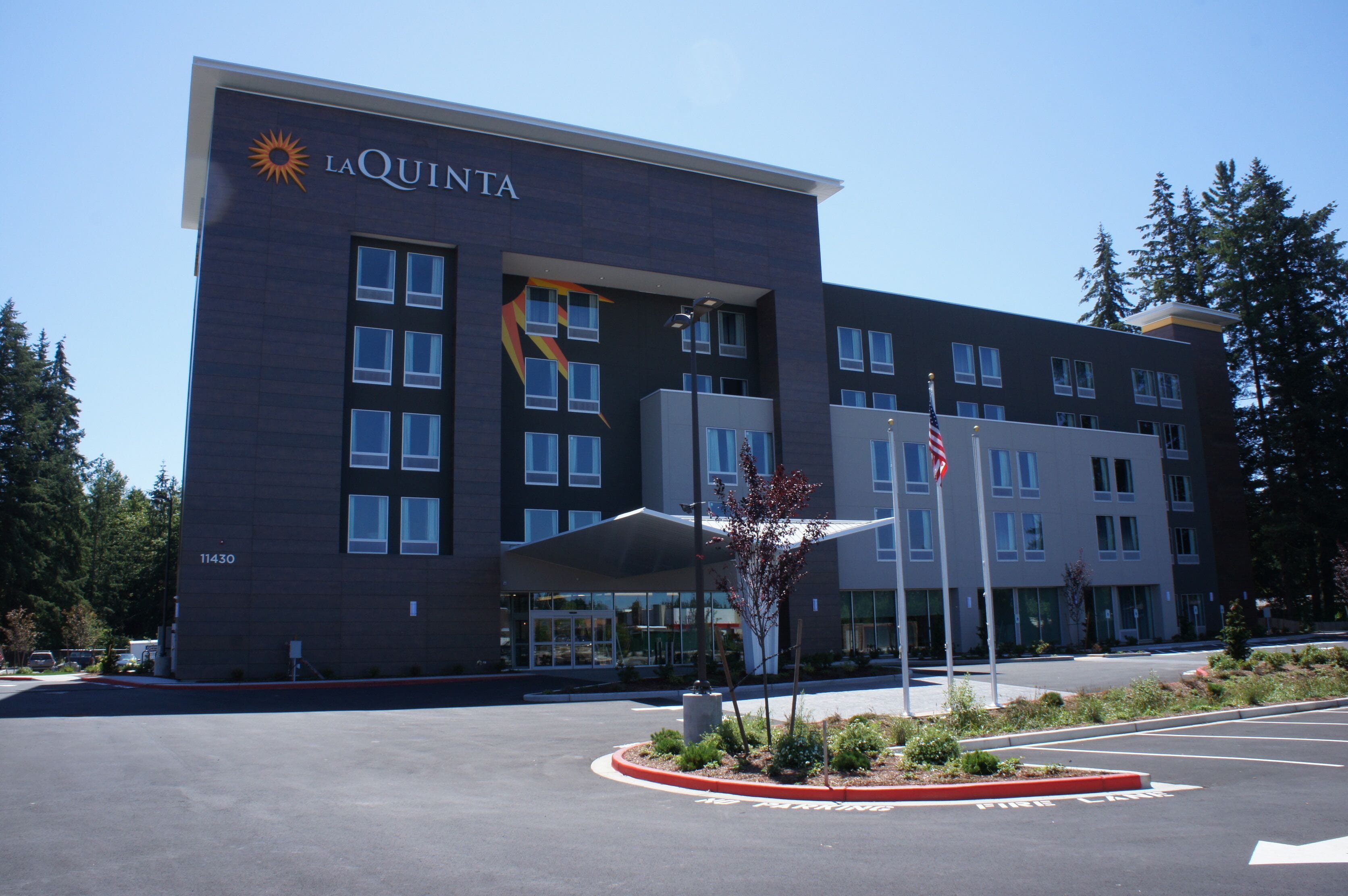 A La Quinta hotel with a modern design, featuring a large entrance and a parking lot.