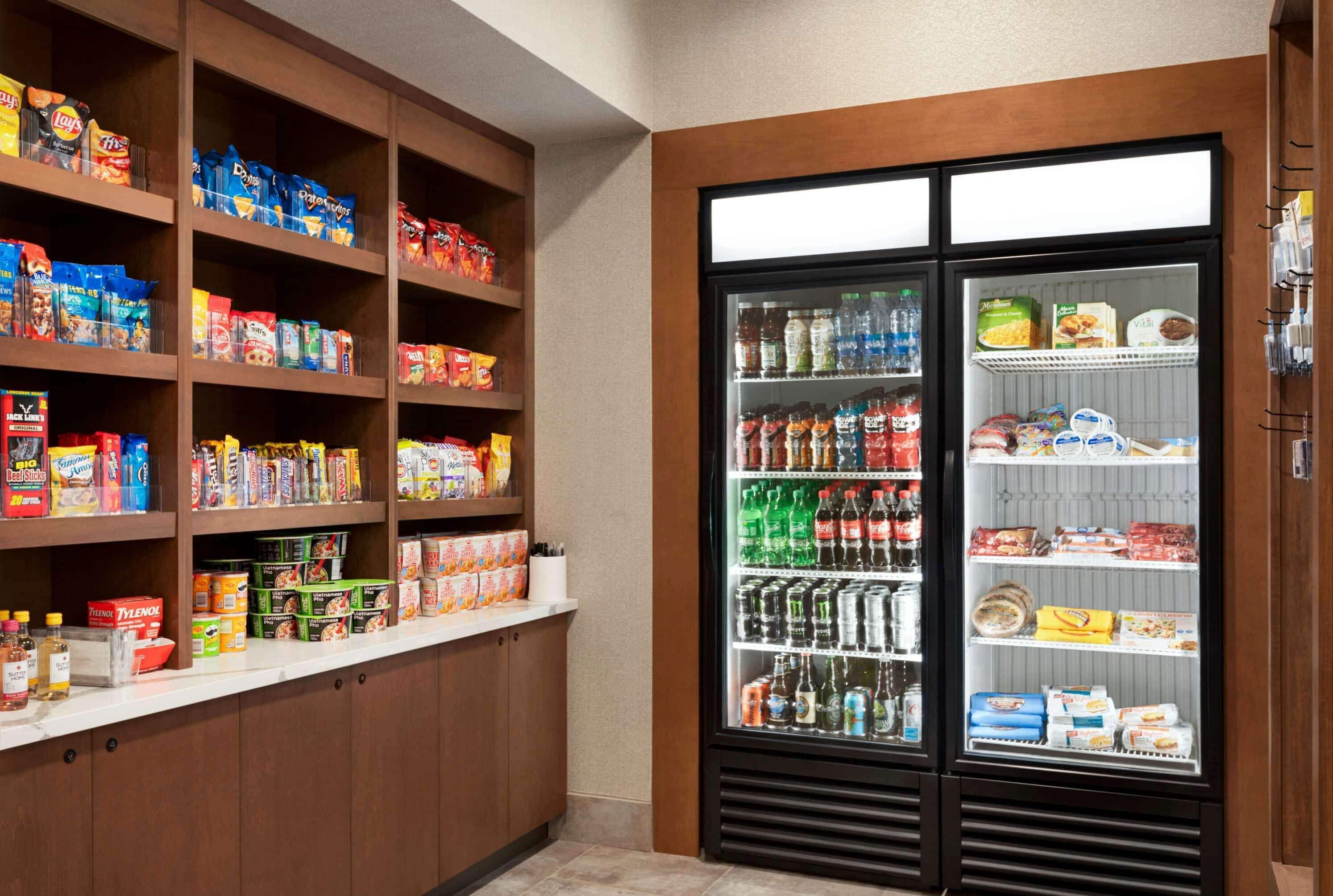 A well-stocked pantry with various food items and a beverage refrigerator.