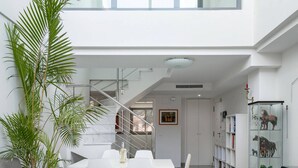 Ein modernes Interieur mit Essbereich, Treppe und einer Vitrine.
