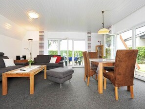 A modern living room with a sofa, coffee table, and dining area.