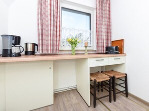 A kitchenette with a coffee maker, a kettle, and a toaster on the counter. - Ferienhaus am Tief in Neuharlingersiel - Ferienhaus am Tief (Neuharlingersiel)