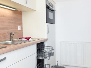 A kitchen with a built-in dishwasher, a microwave, and a sink.