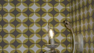 A wall with a geometric pattern and a wall-mounted light fixture.