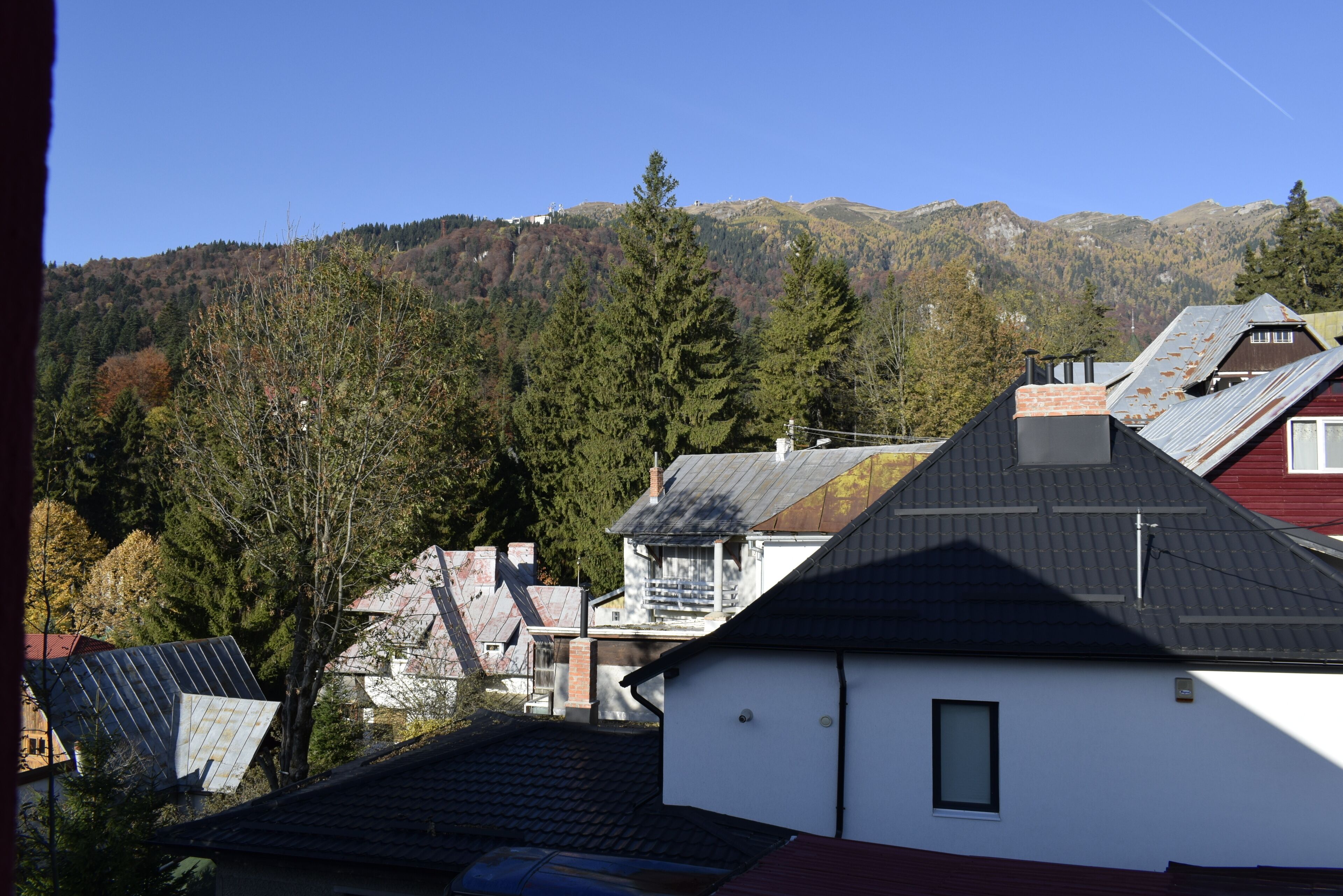 A residential area with houses, a mountain in the background, and a clear sky.