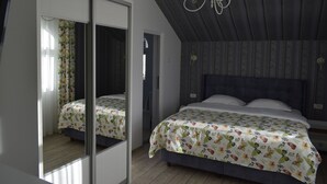 A bedroom with a large mirror, a bed with floral bedding, a chandelier, and a patterned ceiling. - Pensiunea Nicolas (Sinaia)