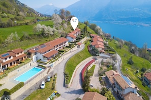 Un hôtel situé sur une colline, doté d’une piscine, de panneaux solaires et offrant une vue sur un lac.