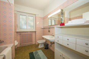 Kombinasi shower/bathtub, pengering rambut, kloset, dan handuk