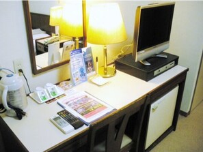 Work and unwind in comfort with a desk, TV, and refrigerator.
