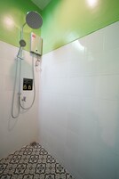 Una ducha con cabezal de ducha de mano y panel de control en la pared.