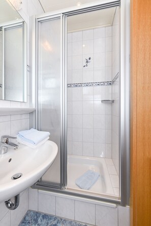 Regadera, toallas, jabón, papel de baño 