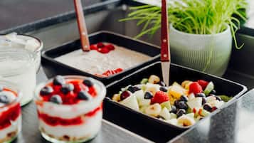 A variety of desserts including a layered parfait, a fruit salad, and a dessert with whipped cream and berries.