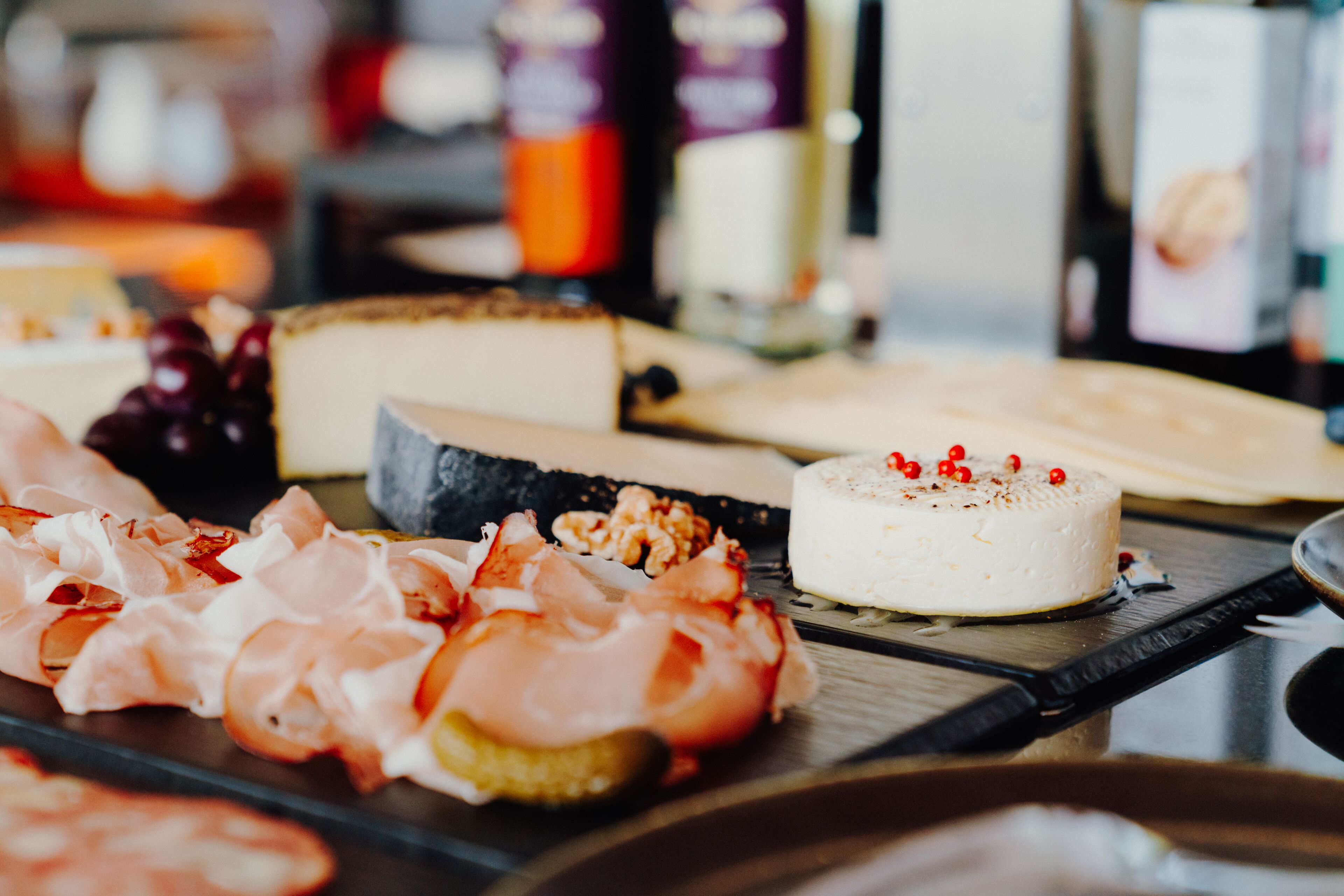 A variety of cheeses and cured meats on a wooden board.