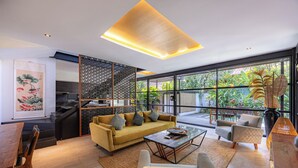 Un salon moderne comprenant un canapé, des fauteuils, une table basse et un coin repas.