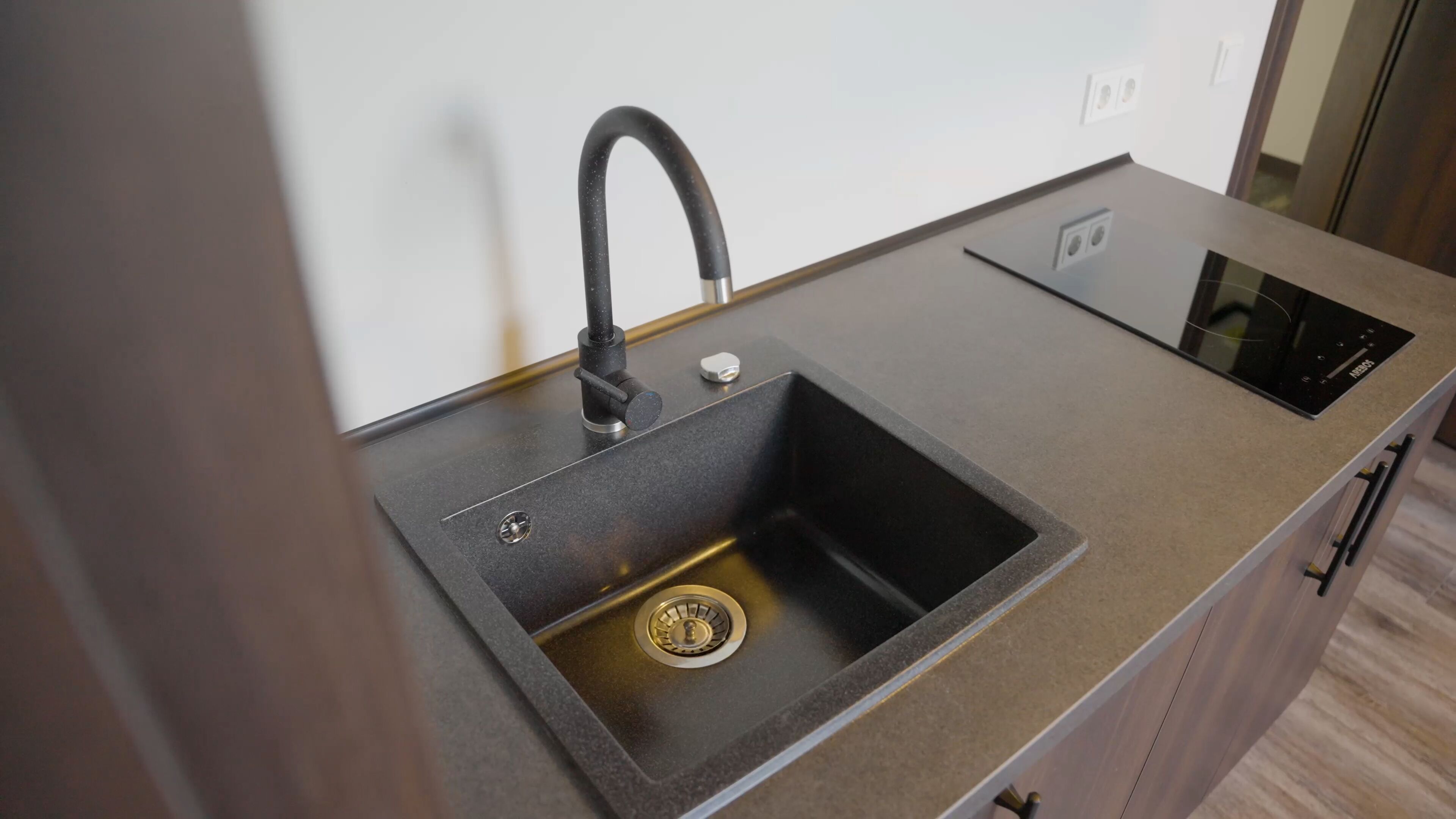 A modern kitchen with a built-in sink, a faucet, and a stove.