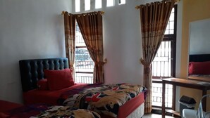 Una habitación con dos camas, un escritorio y una silla.
