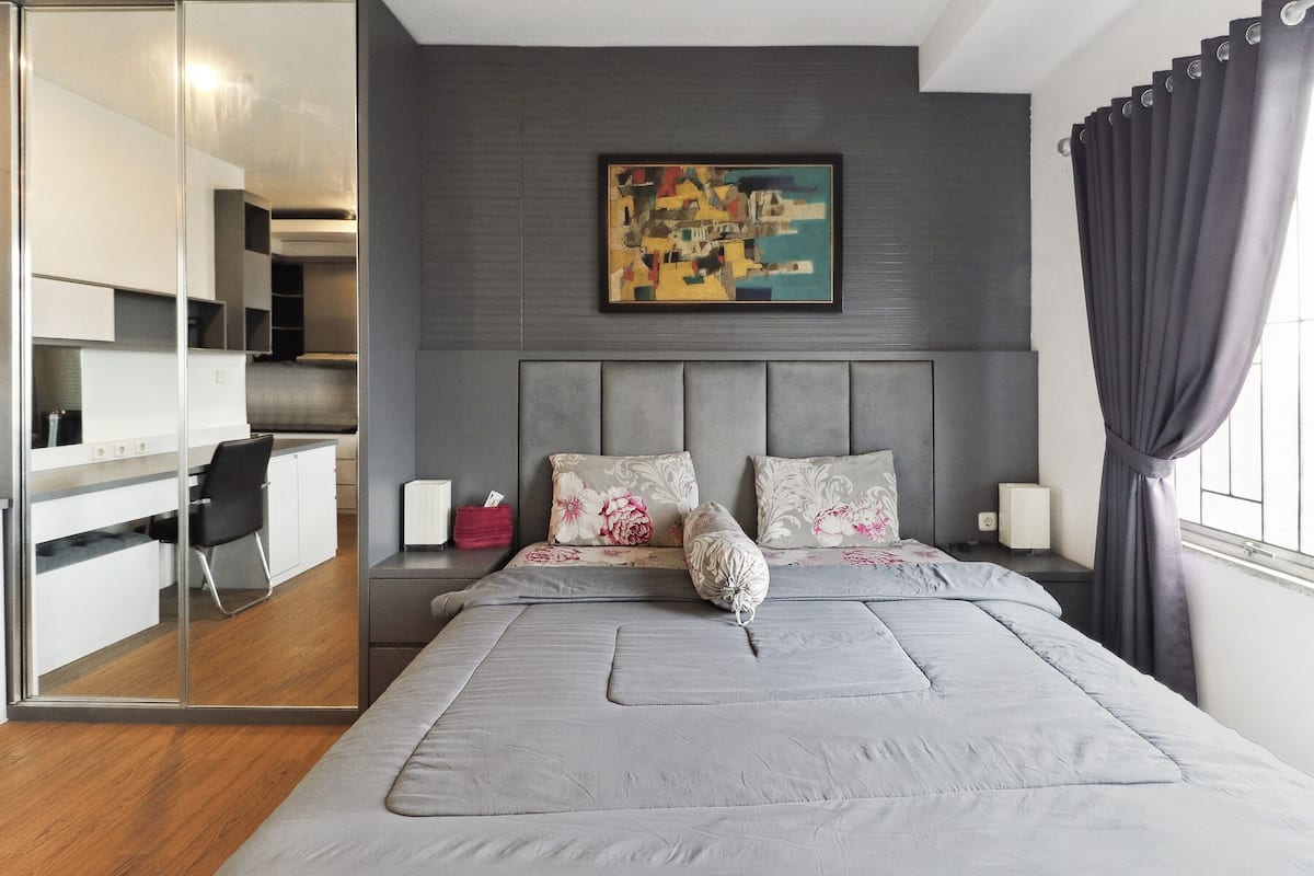 Un dormitorio moderno con una cama, un escritorio y una silla.
