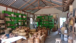 A storage room with shelves filled with woven baskets and containers. - Adji Homestay - Hostel (Muntuk)